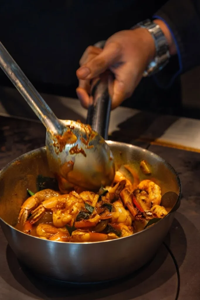Le chef fait sauter des gambas dans une sauteuse