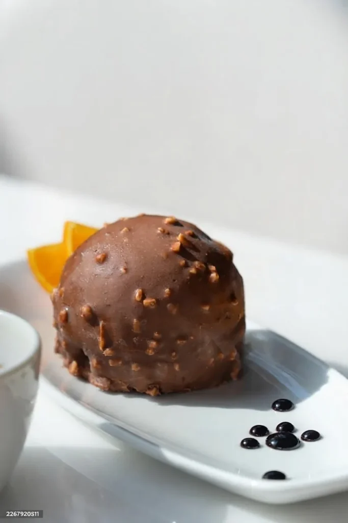 Sphère au chocolat et éclats de noisette, dessert à l'assiette