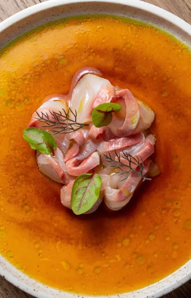 Carpaccio de poisson, bouillon safrané et jeunes pousses